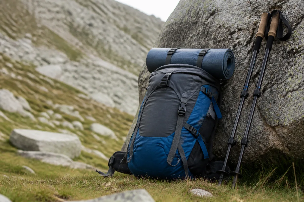 Petite tente verte installée sur un replat herbeux de moyenne montagne à la lumière du soir